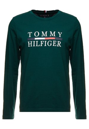 Camiseta de manga larga verde hecha de algodón. Presenta el logo "TOMMY HILFIGER" en blanco con franjas horizontales en azul marino y rojo. Cuello redondo.