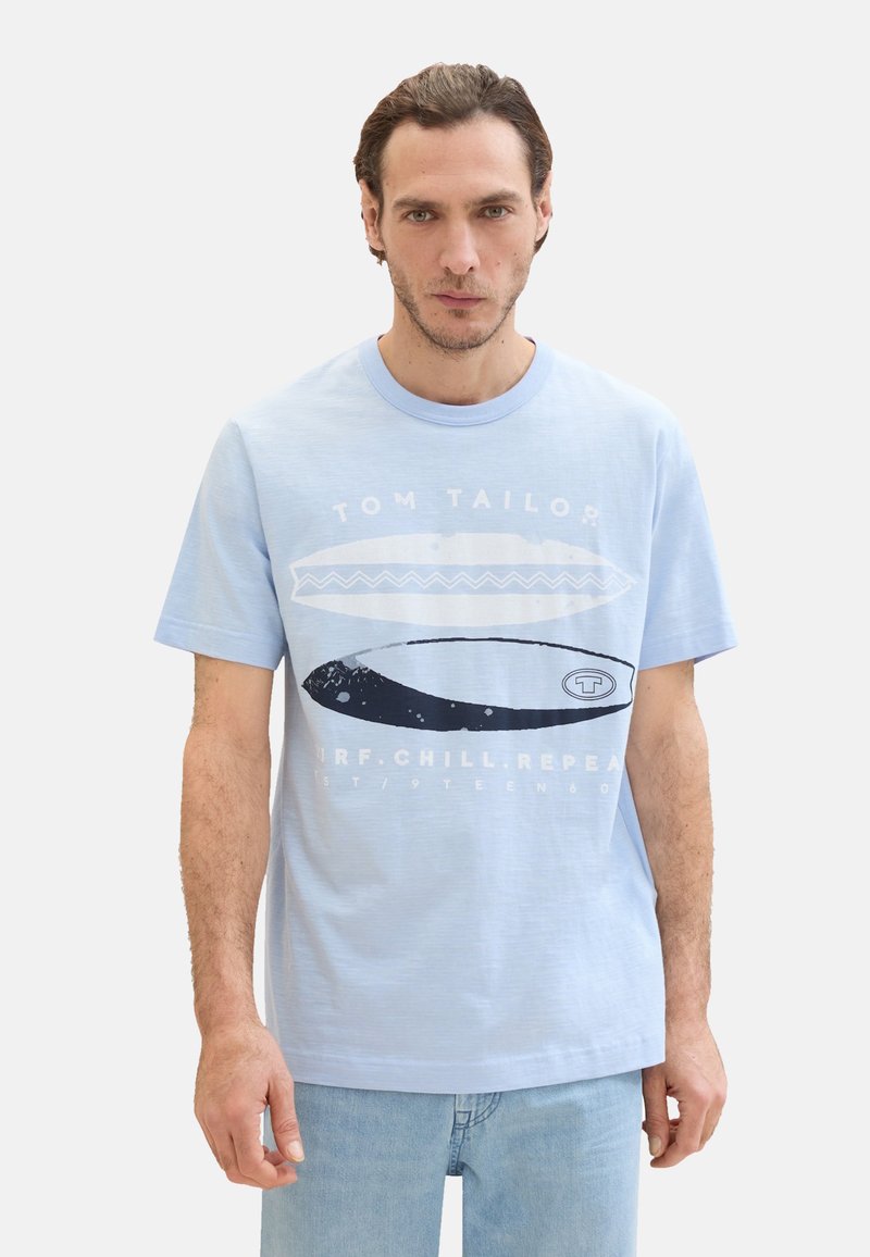 Svetlo modré bavlnené tričko s krátkymi rukávmi, s grafickým dizajnom surfboardov a textom „TOM TAILOR“ v bielej a čiernej farbe.