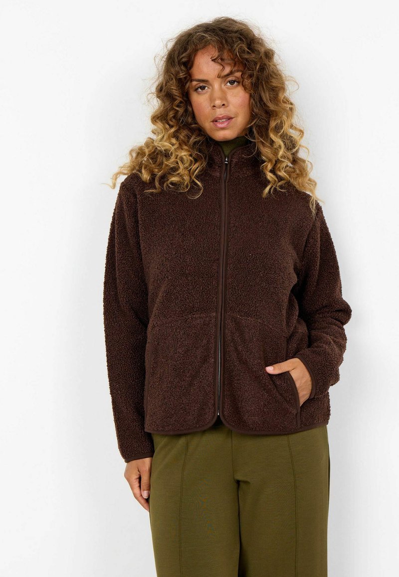 Bruine fleece ritjack met een zachte, textuur gebaseerde afwerking, voorzien van twee voorzakken en een contrasterende rits, gecombineerd met olijfgroene broek.