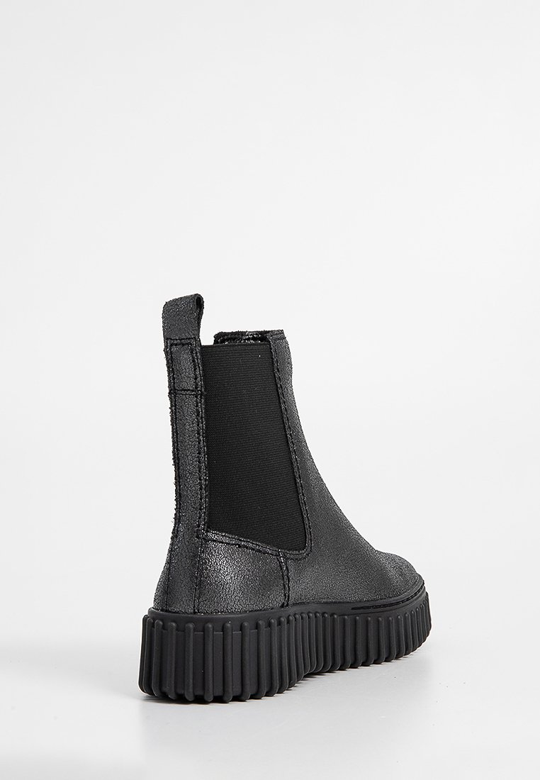 Schwarze Leder-Ankle-Boots mit elastischen Seiteneinsätzen, strukturiertem Obermaterial und einer groben Gummisohle mit horizontalen Rillen.