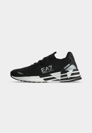 Černobílé tenisky Emporio Armani EA7 Crusher s tlustou podrážkou a logem na boku, zobrazené v pravém profilu na jednoduchém pozadí.