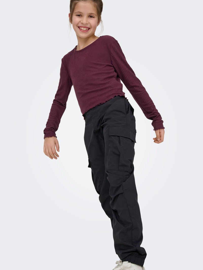 Haut côtelé à manches longues de couleur bordeaux avec ourlet raccourci, associé à un pantalon cargo noir avec poches latérales, poignets froncés et coupe décontractée.