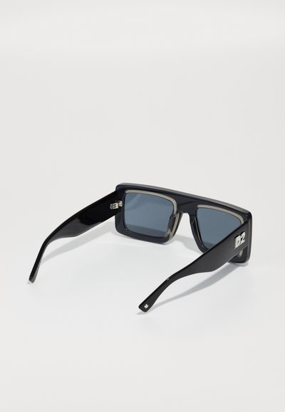Black sunglasses with square frames, gray lenses, and a glossy finish. Features subtle branding on the side and a streamlined design.
