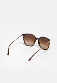 Ochelari de soare tortoise brown cu lentile degradate. Formă pătrată, accente subțiri din metal auriu pe temple și un finisaj lucios.