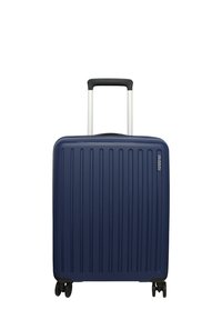 Valigia rigida blu navy con texture a coste verticali, manico telescopico argentato e quattro ruote nere per la mobilità.