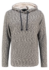 Huppari, jossa on harmaata ja beessiväristä neulosta, joka on laikukasta. Varustettu nyöreillä, pitkillä hihoilla ja pehmeällä, teksturoidulla sisäpuolella. Rennon tyylinen.