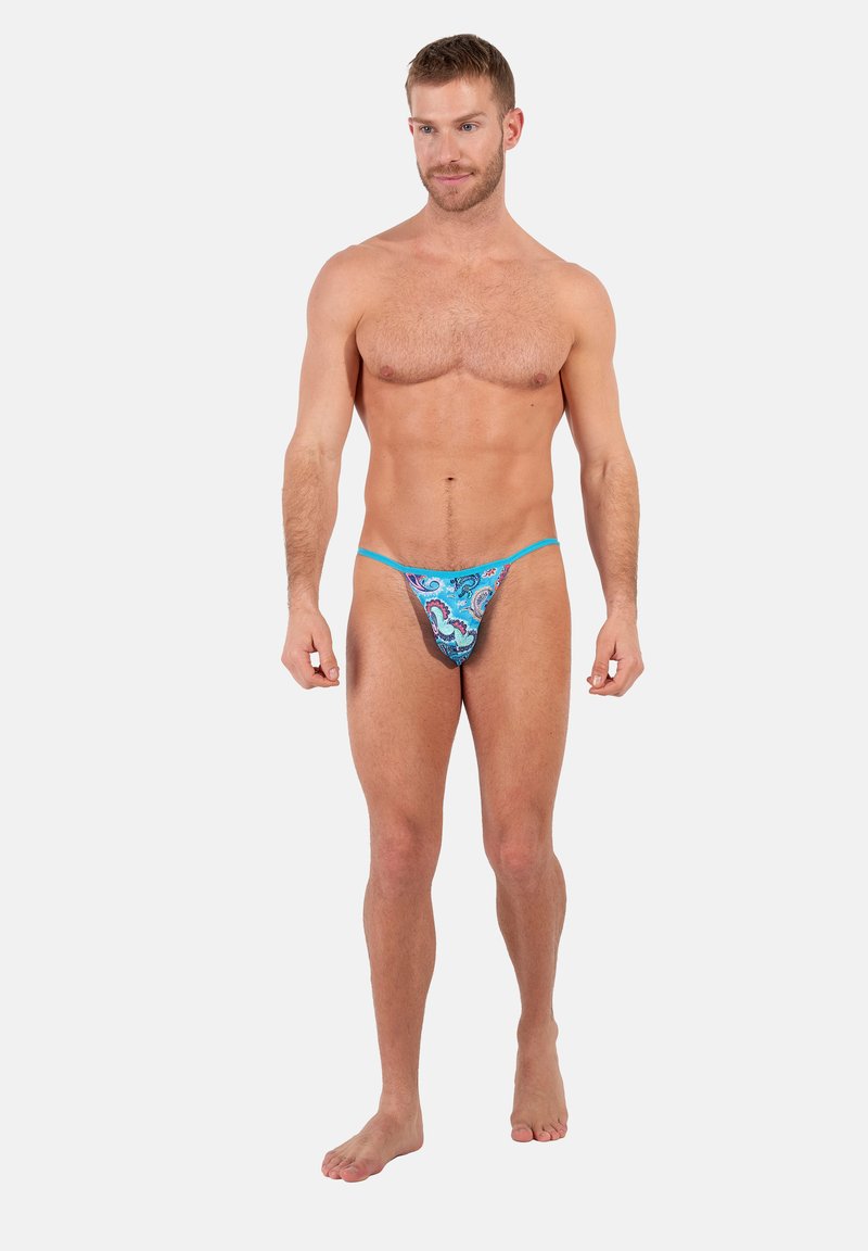 Männlicher Tanga in leuchtendem Blau mit Paisleymuster. Verfügt über dünne Träger, einen niedrigen Schnitt und ein strukturiertes Material.