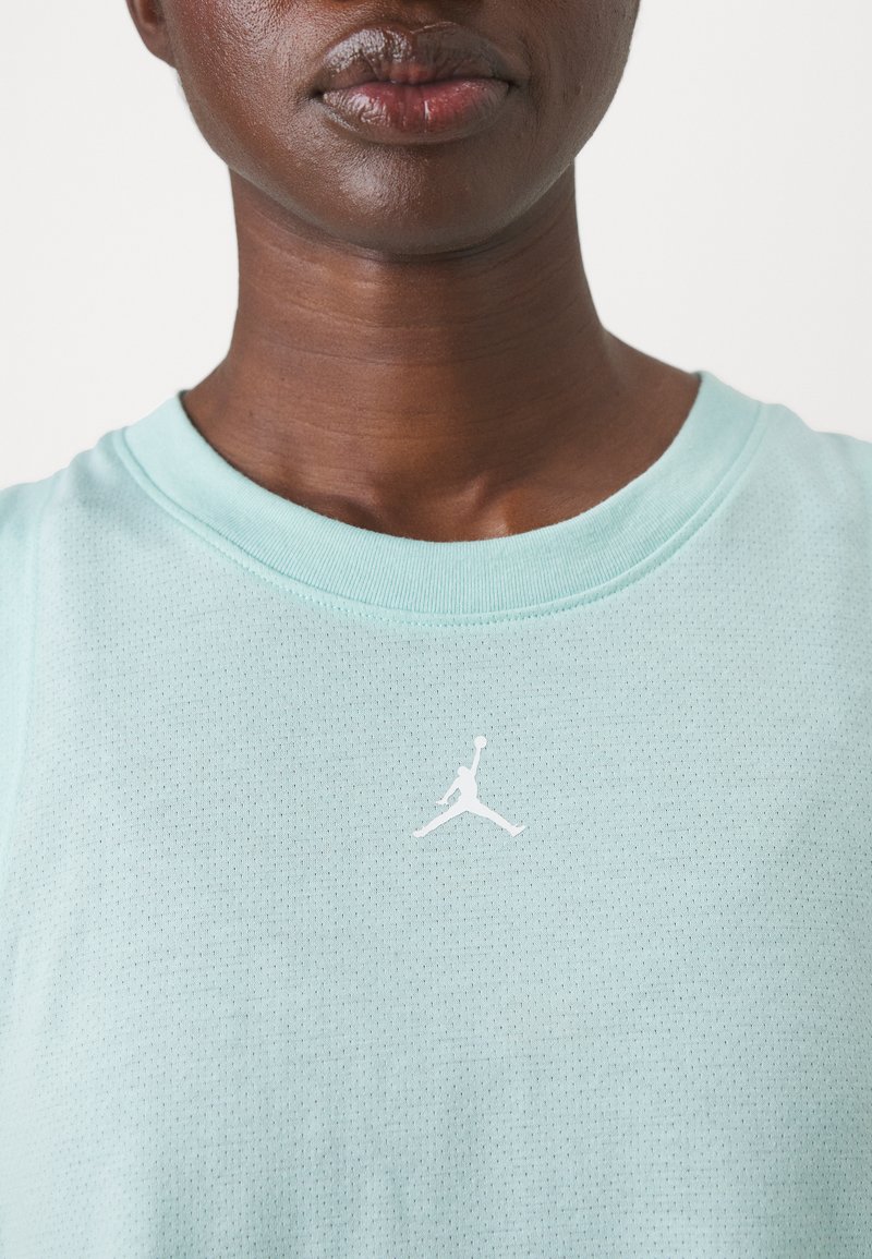 Jasno miętowa koszulka sportowa z teksturowanej tkaniny, z białym logo Jumpman na piersi i ribbowym okrągłym dekoltem.