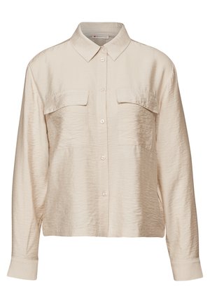 Chemise beige à manches longues en tissu lisse et léger. Présente un front boutonné, un col et deux poches poitrine. Texture douce.