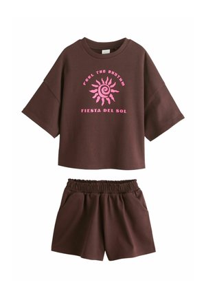 Braunes kurzärmeliges Oberteil mit pinkem Sonnenmotiv und dem Text "Feel the Rhythm Fiesta del Sol", kombiniert mit passenden braunen Shorts mit elastischem Bund.