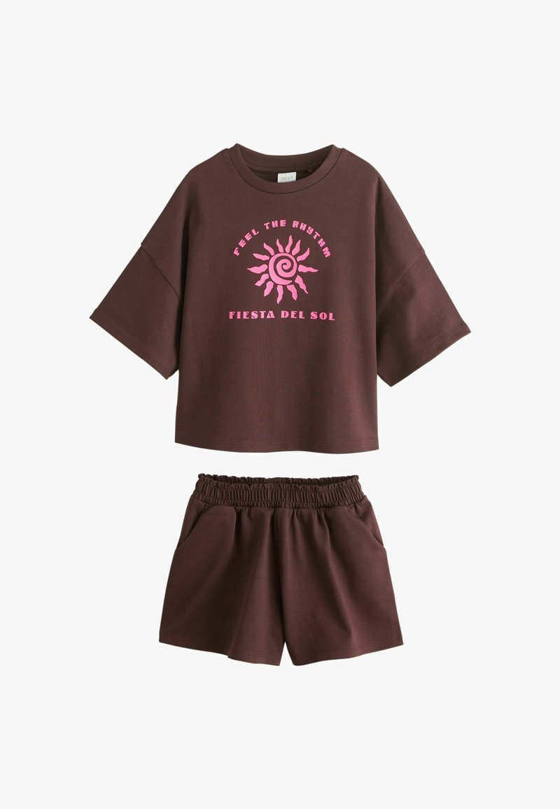 Brązowy krótki top z różowym nadrukiem słońca i napisem "Feel the Rhythm Fiesta del Sol", zestawiony z dopasowanymi brązowymi szortami z elastycznym pasem.