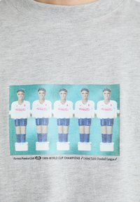 Šedá bavlnená mikina s grafickým motívom piatich stolných futbalistov v bielych a modrých uniformách s nápisom "Fantalzy FC".