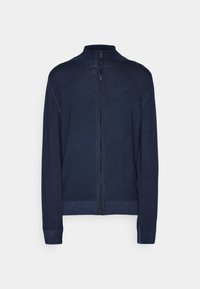 Marinblå stickad zip-up tröja med hög krage och långa ärmar mot en platt vit bakgrund.