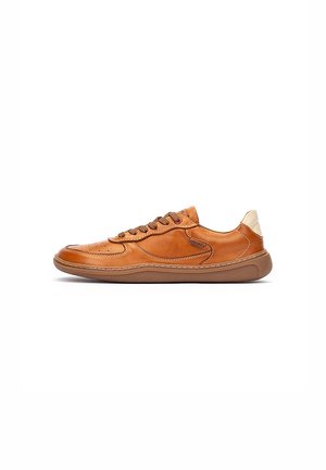 Zapatilla de cuero color marrón claro con puntera redondeada, superficie texturizada, ocho cordones marrones y un detalle de cuero claro en el talón. Suela de goma.