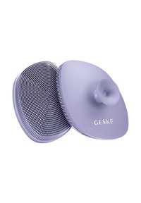 Spazzola per capelli viola con un design arrotondato e doppio lato, presenta setole di plastica fini su un lato e una superficie liscia e bombata sull'altro.
