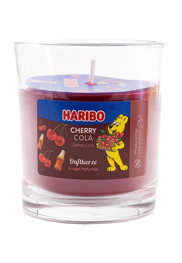 Vela de aroma a cola de cereza púrpura en un recipiente de vidrio transparente con una mecha blanca. La etiqueta presenta ilustraciones de cerezas y botellas de cola.