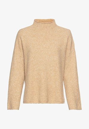 Beige, wollen turtleneck sweater met een losse pasvorm. Heeft lange mouwen, een geribbelde halslijn en een lichte textuur over de stof.