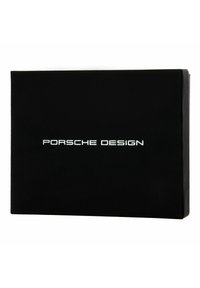 Scatola rettangolare nera con finitura opaca. Presenta il testo "PORSCHE DESIGN" in argento metallico, centrato sul davanti.