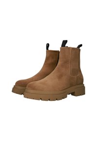 Botas de tobillo de ante marrón con suela de goma gruesa, paneles laterales elásticos y tiradores. Presenta una superficie texturizada y un diseño simple.