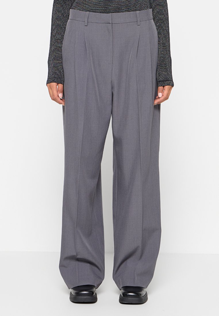 Grau maßgeschneiderte Hose mit hoher Taille, Falten und weitem Bein. Hergestellt aus einem glatten Stoff, mit einem sicheren Bund und eleganten Taschen.