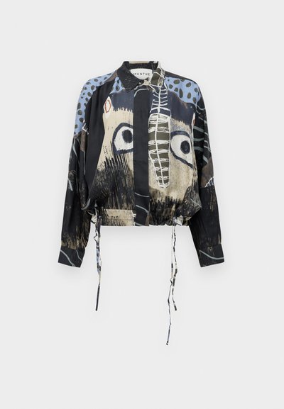 Cropped black jacket with playful animal prints, featuring a button-up front, drawstring hem, and long sleeves with a mixed-pattern design.