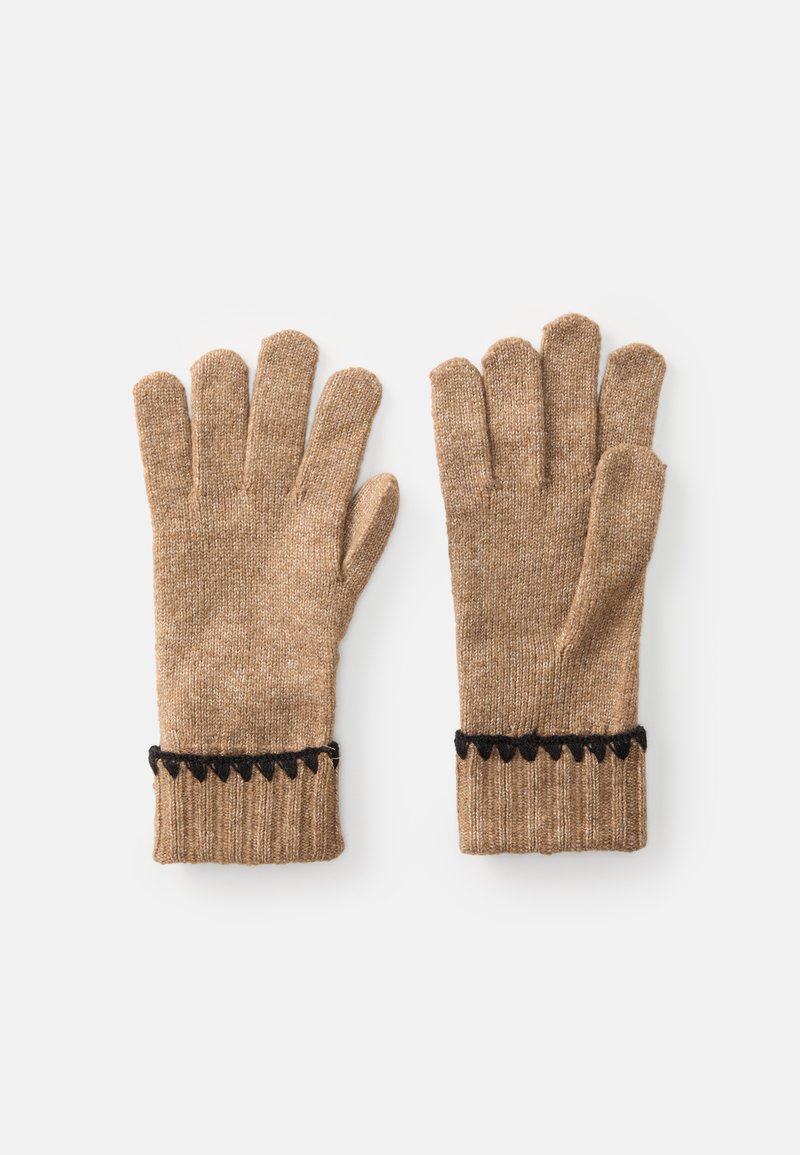Et par beige strikkede handsker med sorte zigzag-kanter på ribbede manchetter, lagt fladt på hvid baggrund.