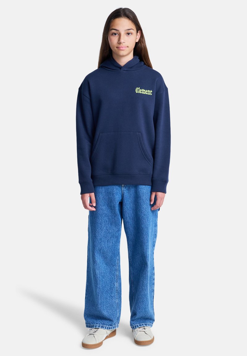 Hoodie navy avec "Element" en vert fluo, doté d'une poche kangourou. Associé à un jean large bleu clair et des baskets crème.