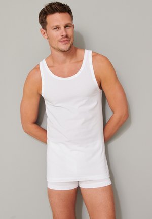 Hvid bomulds tanktop med rund halsudskæring, parret med hvide trusser. Simpelt design, glat tekstur, tætsiddende form, ingen synlige mønstre.