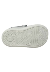 Sole di una sneaker bianca con un motivo di presa testurizzato, logo circolare e la dicitura "FLEXIBLE ACTION SYSTEM" stampata. Presenta un battistrada pronunciato e bordi lisci.