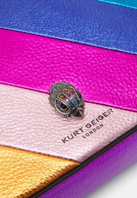 Borsa a mano in pelle sintetica colorata con strisce blu, rosa, viola e oro. Decorata con un elegante dettaglio a forma di gufo tempestato di gioielli.