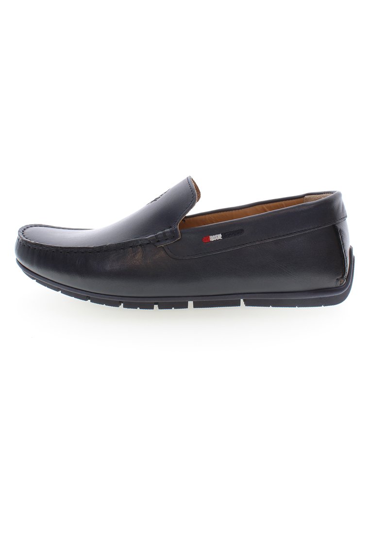 Scarpa slip-on in pelle nera con punta arrotondata, cuciture dettagliate e finitura testurizzata. Presenta una suola in gomma bianca a contrasto.