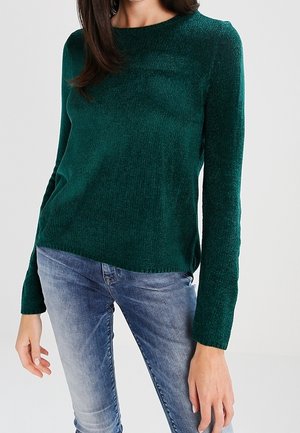 Maglione verde lavorato a maglia con scollo rotondo e maniche lunghe, caratterizzato da una finitura testurizzata e una vestibilità ampia, abbinato a jeans blu chiaro.
