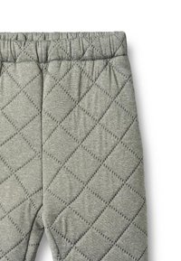 Hallid tikitud püksid elastse vöökohaga, millel on teemantmustritega pehme tekstuur. Materjal paistab olevat veniv ja mugav.