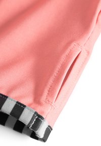 Koraal kleurige sportshorts met een steekzak, een zwart-grijze geruite tailleband en een gladde, gestructureerde stof.