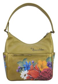 Gouden leren handtas met een gebogen vorm, met een voorkantvak. Het ontwerp bevat kleurrijke bloemenpatronen en een handtekening.