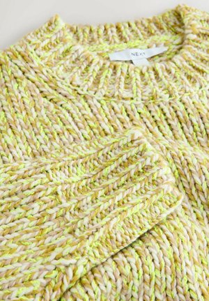 Tejelt pulóver krém, sárga és zöld árnyalatokban. Vastag, textúrált anyaggal rendelkezik, kerek nyakkal és bordás mandzsettákkal. Márkajelzés látható.
