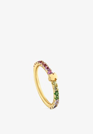 Anillo de oro con piedras preciosas multicolores engastadas a lo largo de la banda y un pequeño detalle dorado en forma de trébol.