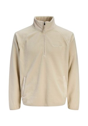Beige fleece pullover with a half-zip collar, raglan sleeves, side pockets, and a soft textured finish. Logo detail on the chest.