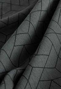 Textil i mörkgrått med ett geometriskt mönster av sammanlänkade linjer i svart. Slät textur med synliga vävdetaljer.