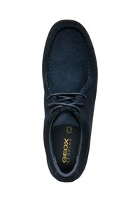 Zapato de ante azul oscuro con punta redondeada, diseño de cordones y costuras en contraste. Presenta una plantilla acolchada etiquetada "GEOX RESPIRA."