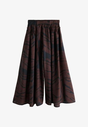 Brązowe szerokie nogawki culottes wykonane z lekkiego materiału, z czarnym abstrakcyjnym wzorem, z elastycznym pasem dla swobodnego dopasowania.