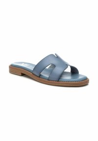 Sandalia de cuero azul con dos correas anchas y diseño recortado. Suela de goma marrón claro, textura suave y estilo sencillo y casual.