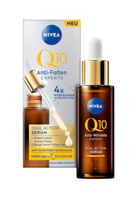 NIVEA Q10 Anti-Aging Expert Serum in einer braunen Glas-Glasflasche mit goldener Kappe, platziert neben einer silbernen Box mit blauer und gelber Schrift.