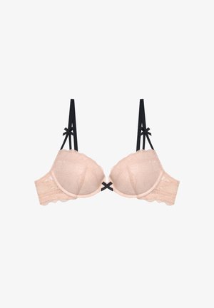 Sujeción beige acolchada de encaje con tirantes negros ajustables y pequeños lazos negros en los tirantes y en el centro delantero.