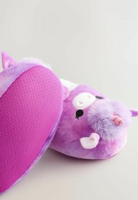 Chaussons licorne violette avec une texture douce, une forme arrondie et une semelle antidérapante à points. Les détails remarquables incluent une corne et des traits de visage.