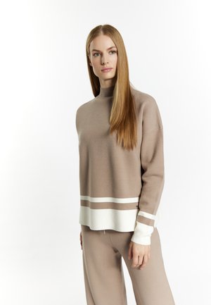 Beige sweater with a mock neck, featuring white and darker beige stripes at the hem and cuffs. Soft, textured knit fabric.