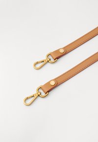 Sangle en cuir tanné avec quincaillerie en métal doré et clips aux deux extrémités, comportant un emblème circulaire sur un point d'attache.
