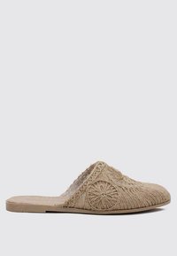 Chaussure en toile beige à bout ouvert avec un dessus tissé texturé, des détails brodés floraux et une semelle plate. Matériau doux avec un design minimaliste.