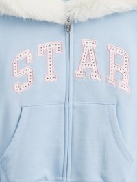 Sweatshirt azul claro com fecho zip, apresentando um colarinho de pelúcia branco, letras rosa com tachas a soletrar "STAR" e um bolso canguru.