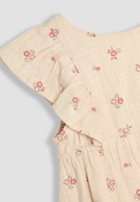 Vestido de tela suave color beige con estampado floral, que presenta mangas con volantes, superficie texturizada y cintura elástica para un ajuste perfecto. Flores delicadas en tonos rosa y blanco.